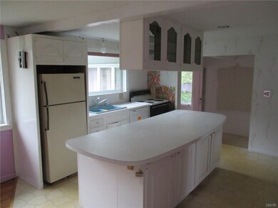 Kitchen  area has a large center island and all ap