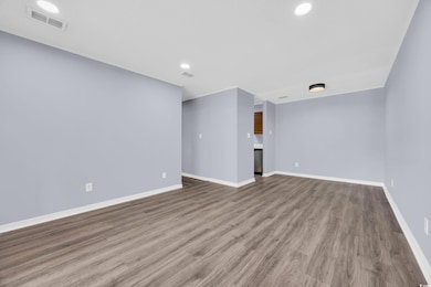 Unfurnished living room featuring wood finished floors and recessed lighting