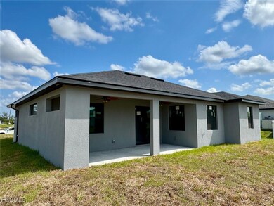 Back of property featuring a patio area, stucco siding, and a yard