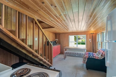 Miscellaneous room with wood ceiling, concrete floors, wood walls, and stairway