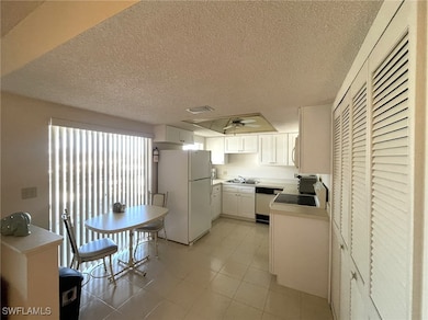 Kitchen with white cabinets, light tile patterned