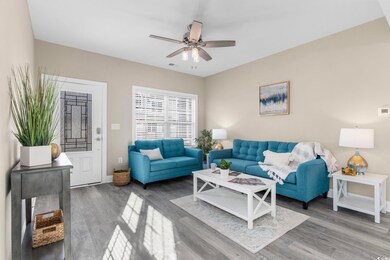 Living room featuring a ceiling fan, wood finished