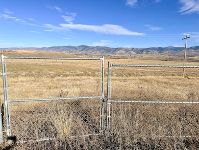 View of yard featuring a mountain view, a gate, and a view of countryside
