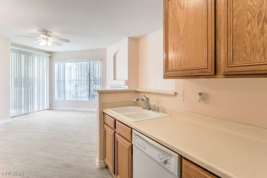 Kitchen with dishwasher, brown cabinetry, light countertops, a ceiling fan, and open floor plan