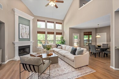Living room featuring a ceiling fan, light wood-t