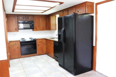 Kitchen with black appliances, light countertops,