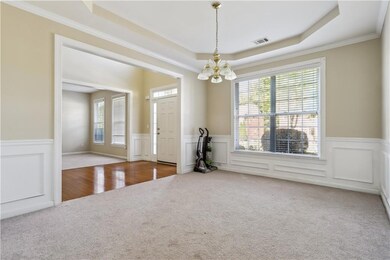 Carpeted spare room featuring a wainscoted wall, a