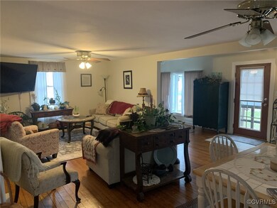Living area with ceiling fan and wood finished flo