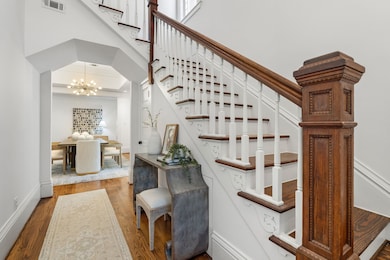 The dramatic foyer introduces the home’s soaring proportions, hardwood floors, original staircase and superb millwork, including a carved newel post, handsome trim work, and extra-tall baseboards. Fresh paint and designer lighting add a contemporary touch throughout.