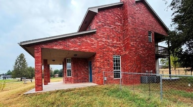 Rear view of house with a patio, brick siding, and a chimney
