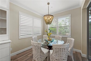 Dining room with dark wood-type flooring, a chande