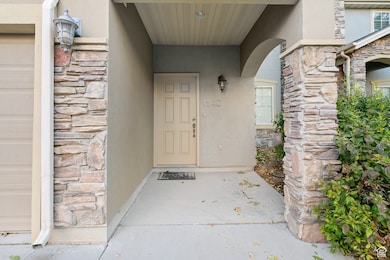 Property entrance with stone siding and stucco siding