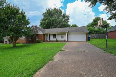 Single story home featuring driveway, an attached garage, and brick siding