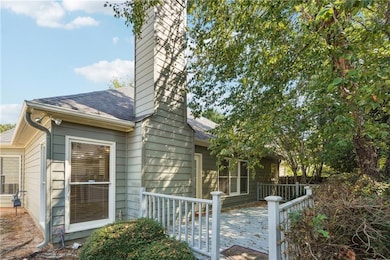 View of home's exterior with a shingled roof, a deck, and a chimney