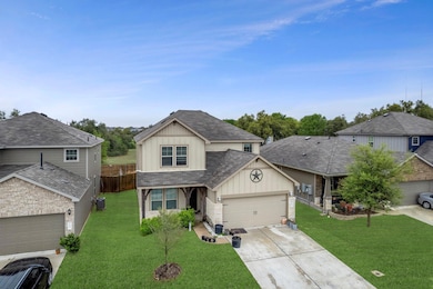 View of front of property featuring driveway, a front yard, roof with shingles, cooling unit, and an attached garage