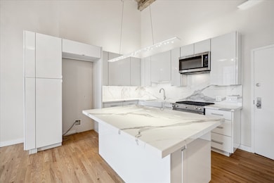 Stunning remodeled kitchen with porcelain counters and backsplash, soft close custom cabinets/drawers, undercabinet lighting, Kitchen aide stainless steel appliances, gas range and breakfast bar seating