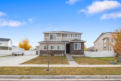View of front of home with stone siding, driveway, and a garage