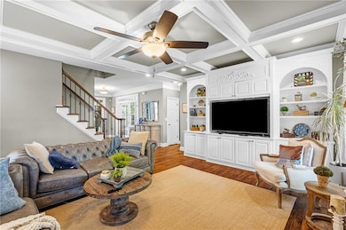 Living room features coffered ceilings and large bookcase
