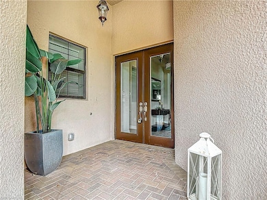 View of exterior entry featuring french doors and stucco siding