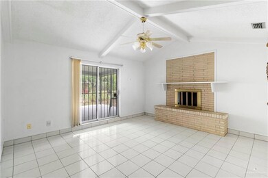Unfurnished living room featuring ceiling fan, a fireplace, lofted ceiling with beams, and a textured ceiling