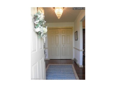 A welcoming entry features hardwood floors that co