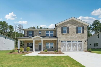 View of front of house featuring brick siding, driveway, a garage, and a front lawn