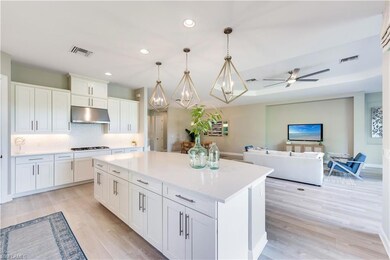 Kitchen with hanging light fixtures, white cabinet