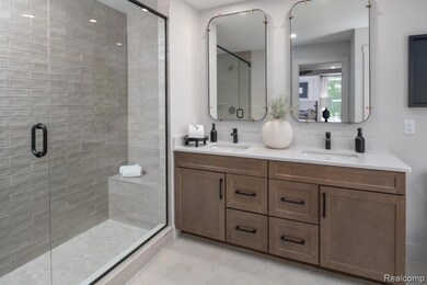 Full bath with a stall shower, double vanity, and light tile patterned floors
