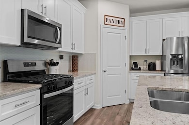 Kitchen featuring white cabinets, hardwood / wood-