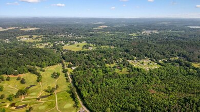 Aerial view of property and surrounding area with a forest