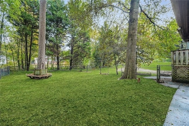 Fenced backyard with a gate and view of scattered trees