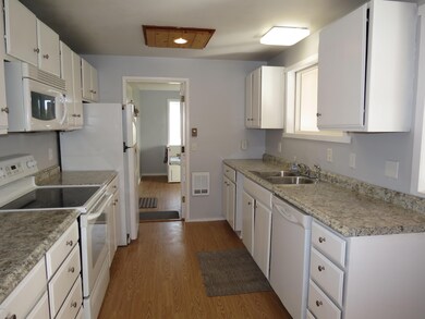 KITCHEN LOOKING TOWARD DEN-UTILITY RM