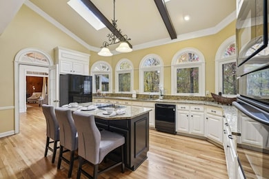 The Chef's Kitchen is a dream with Granite Countertops, White Cabinetry, A Large Island, and Skylights that bathe the space in Natural Light.