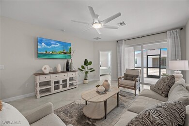 Living room with ceiling fan and light tile patter