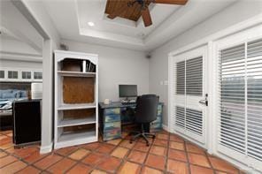 Office featuring tile patterned flooring, a raised ceiling, and ceiling fan