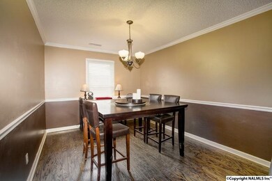 The dining room features wood flooring, crown moulding, and chair rail.