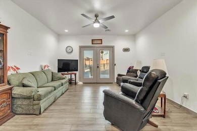 Living room with ceiling fan, french doors, and li