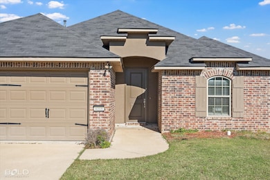 View of front of property with brick siding, an attached garage, a shingled roof, a front lawn, and driveway