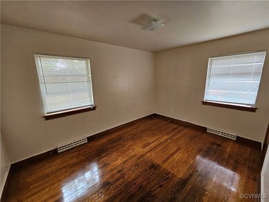 Unfurnished room featuring dark hardwood / wood-style floors and a healthy amount of sunlight