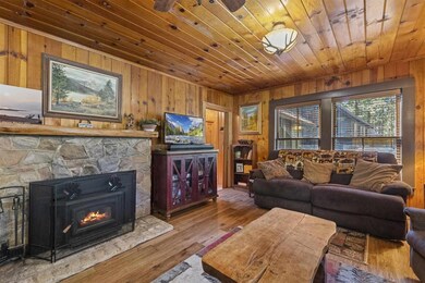 Living room featuring wooden walls, hardwood / wood-style flooring, and wooden ceiling