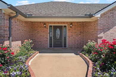 View of exterior entry with brick siding and a shi