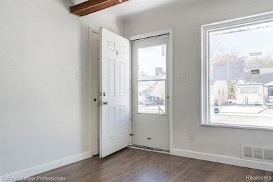 Foyer featuring dark wood-style flooring and beamed ceiling