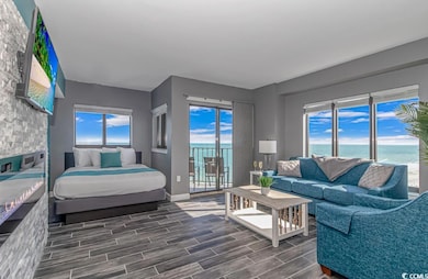 Bedroom featuring a water view, access to outside, and wood tiled floors