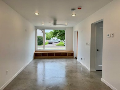 Empty room with concrete flooring and a ceiling fan