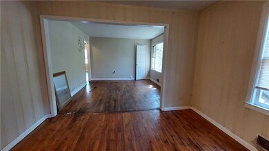 Empty room featuring baseboards and dark wood-type flooring
