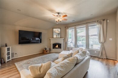 Gather the family and guests together in your lovely living room! Featuring high ceilings, dark stained ceiling fan with lighting, custom paint, fireplace with mantel and large windows that provide plenty of natural lighting throughout the day.