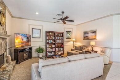 Tiled Family room with a stone fireplace, crown mo