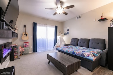 Living room featuring a ceiling fan and carpet flo