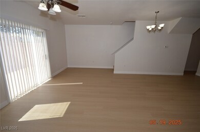 Spare room featuring a chandelier, a ceiling fan,