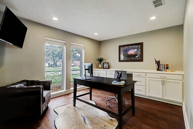The generous study has custom credenza cabinets, n